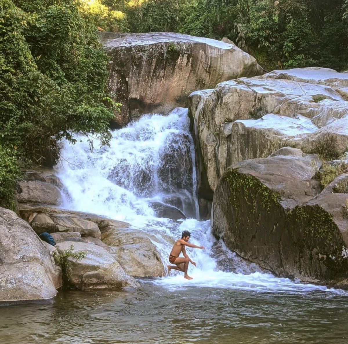 Dani Sierra leaping through a waterfall pool